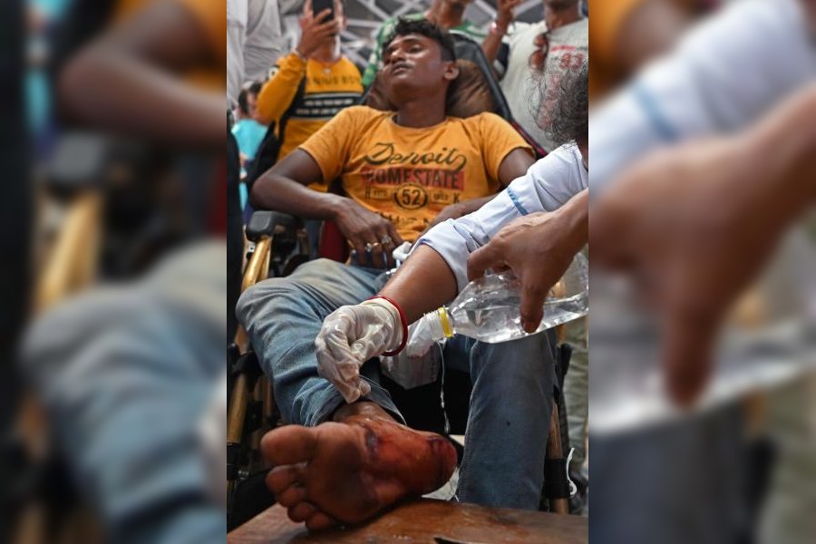 An injured passenger of the Bangalore-Howrah Superfast Express receives first-aid after he arrived at Howrah station on Saturday