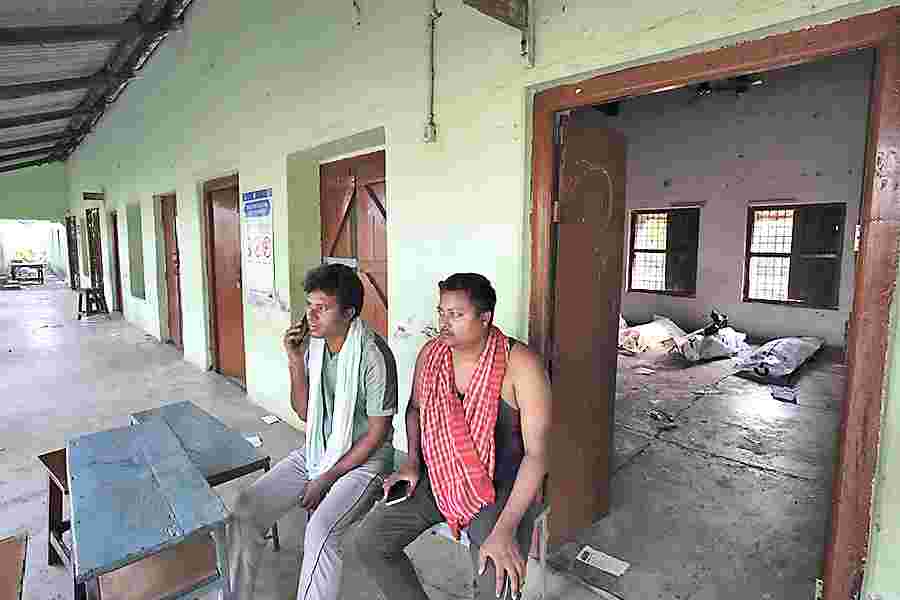 Relatives of 18-year-old Yunus Seikh, a victim of the train accident whose body is missing, sit at Balasore’s Bahanaga High School, which has been converted into a temporary mortuary, on Sunday. 