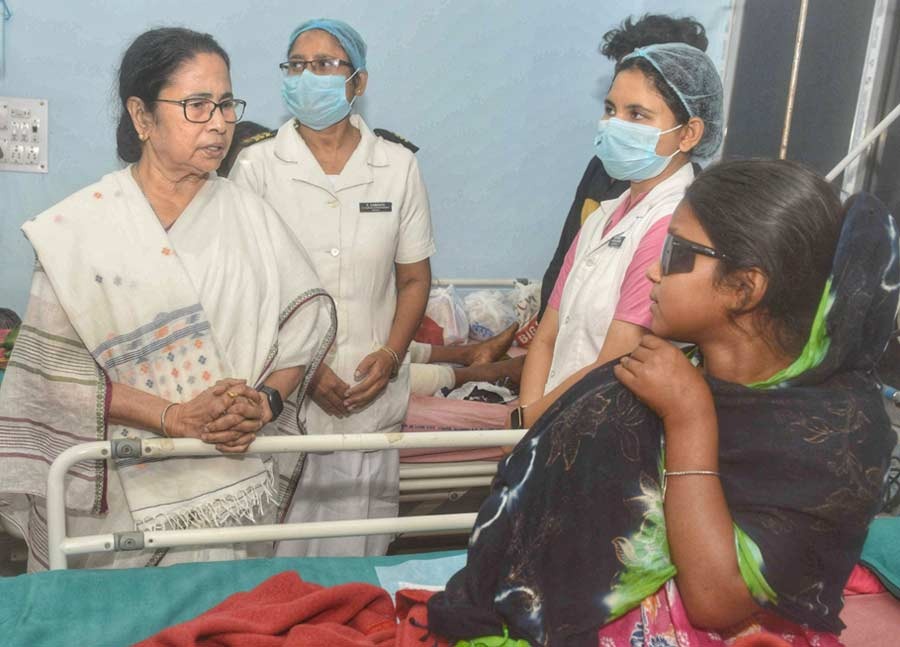 West Bengal chief minister Mamata Banerjee speaks to an injured train passenger at a hospital in Midnapore on Tuesday