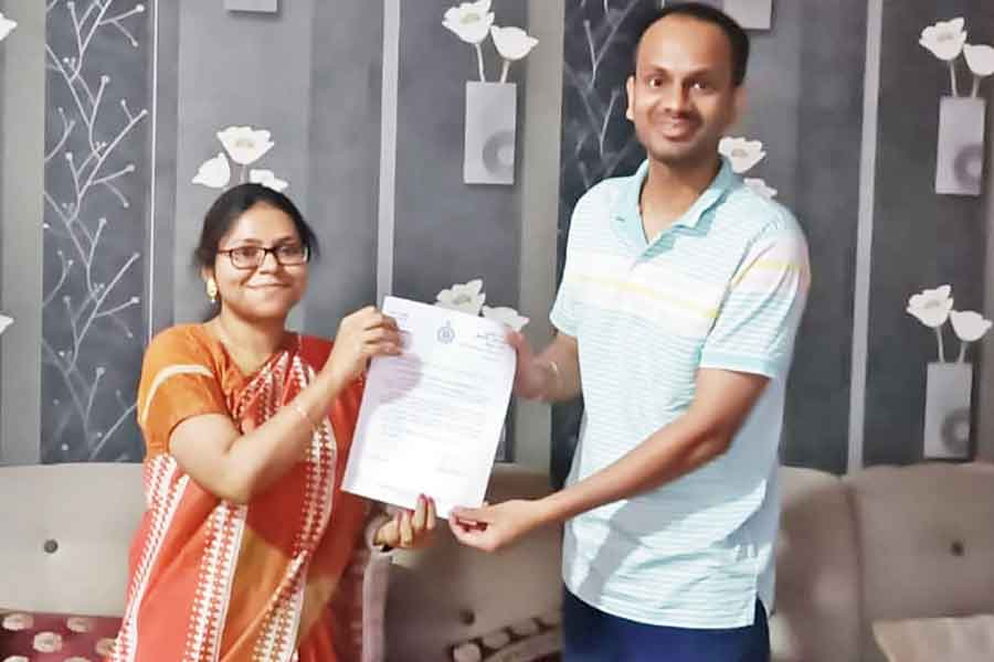 Rishabh Singh being handed the chief minister’s congratulatory letter by Rajarhat block development officer Rishika Das at his Uniworld City home