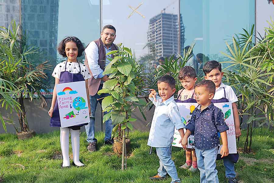 Students plant trees with director of the school, Darshan Mutha