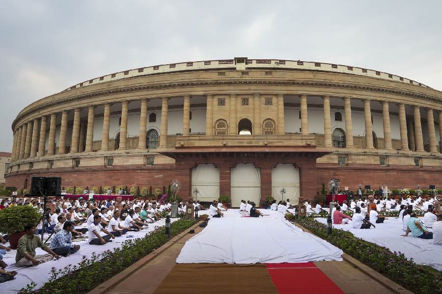 Lok Sabha and Rajya Sabha officials perform yoga during a session on the International Day of Yoga, at the Parliament House complex in New Delhi. 