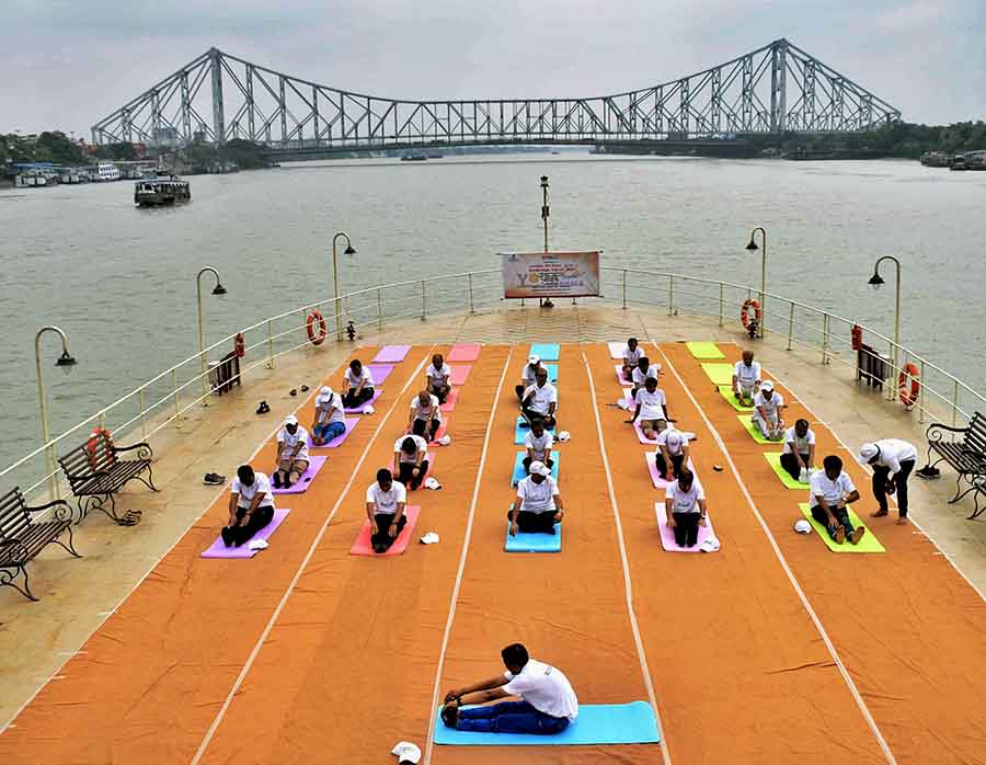 The Syama Prasad Mookerjee Port chairman, employees and other dignitaries performed yoga on the deck of a ship on the Hooghly with the Howrah bridge in the backdrop