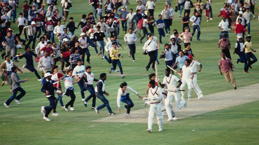 Celebrating spectators flood the square as West Indies batsmen Michael Holding (l) and Joel Garner leave the field after the 1983 Cricket World Cup final Match between India and West Indies
