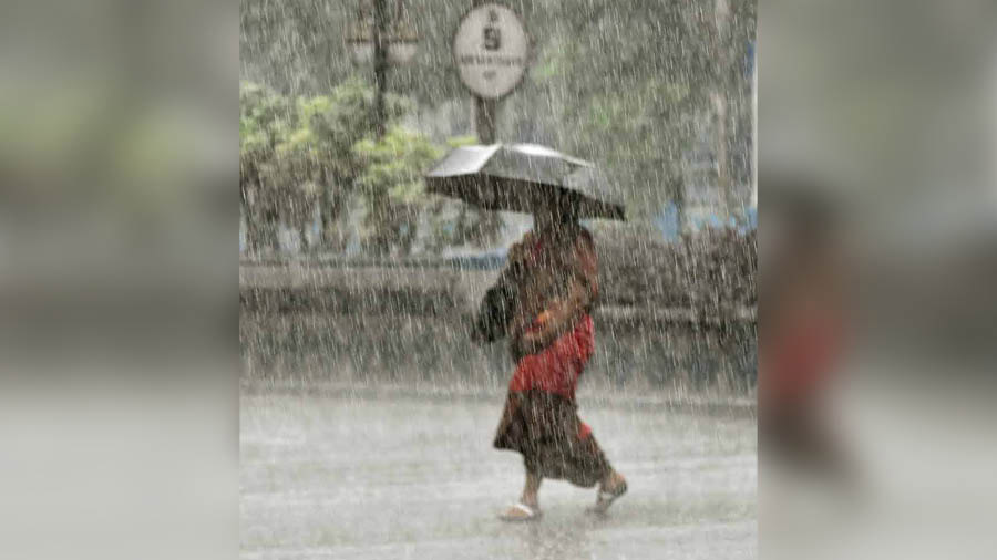 A woman is caught in blinding rain in north Kolkata