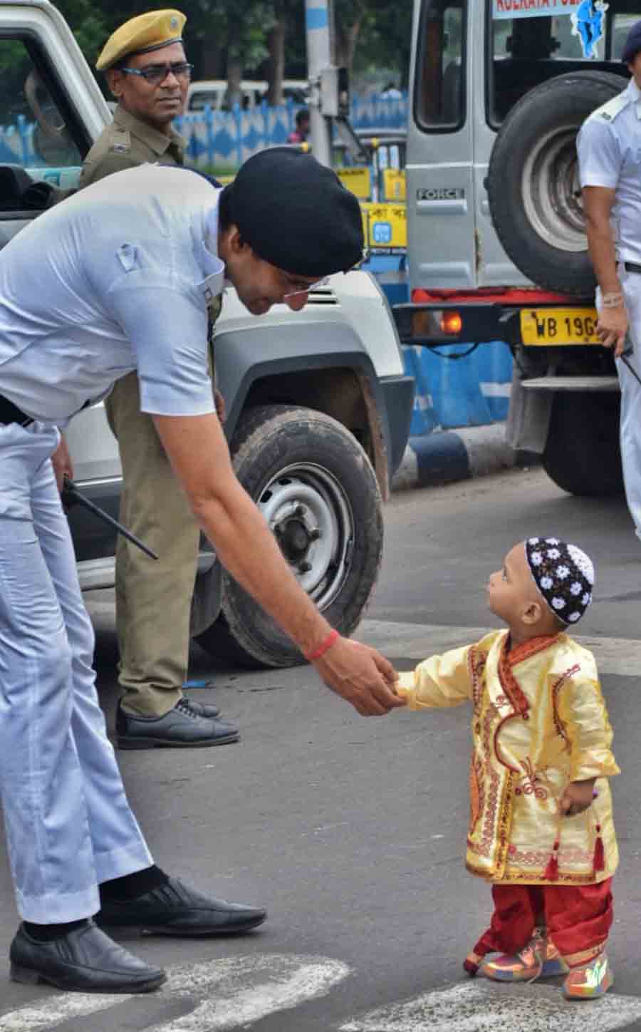 A police personnel befriends a child after prayers at Red Road 