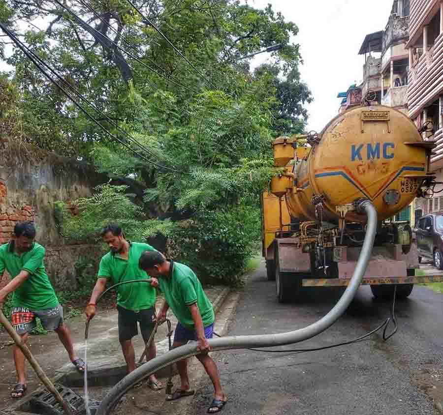Personnel of the Kolkata Municipal Corporation’s solid waste management department desilt sewage pipelines near Amherst Street to prevent waterlogging 
