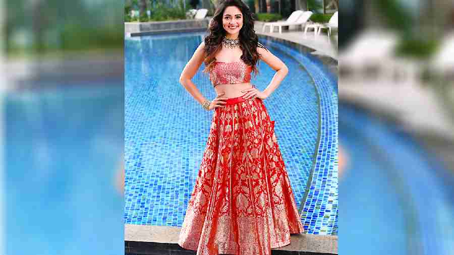 If you have a red Benarasi in mind for your destination wedding look yet do not want the traditional sari, this crimson red lehnga with columns of leaf motif woven in silver zari, complemented by a brocade corset blouse and a sheer dupatta, is a gorgeous look where tradition marries trendy