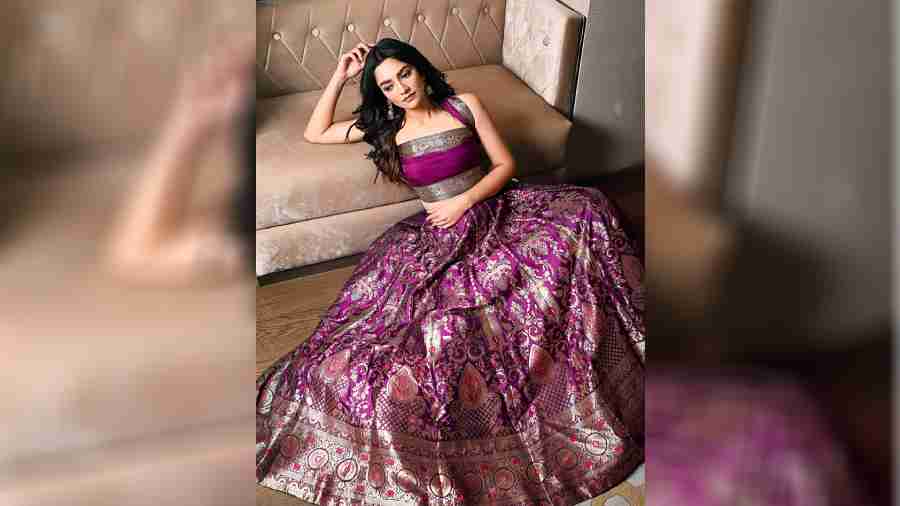 Designed elaborately and intricately with Mughal motifs and meenakari detailing, this purple lehnga is all about redefining the regal vibe as evening wear. The contemporarily draped blouse, the hair worn open and minimal accessorising elevate the regal charm of the attire. 