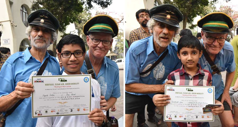 Tony Graham and Roberto D'Andrea, former Melbourne tram conductors, give away certificates to students who took part in a sit-and-draw competition organised as part of Tramjatra 2023. The prize distribution took place in front of Paschimbanga Bangla Academy