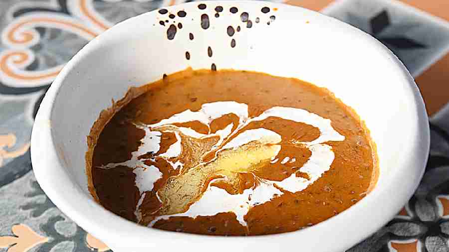 The creamy Dal Makhni where black lentils are slowly cooked for hours finished with enriched butter, cream and spices.