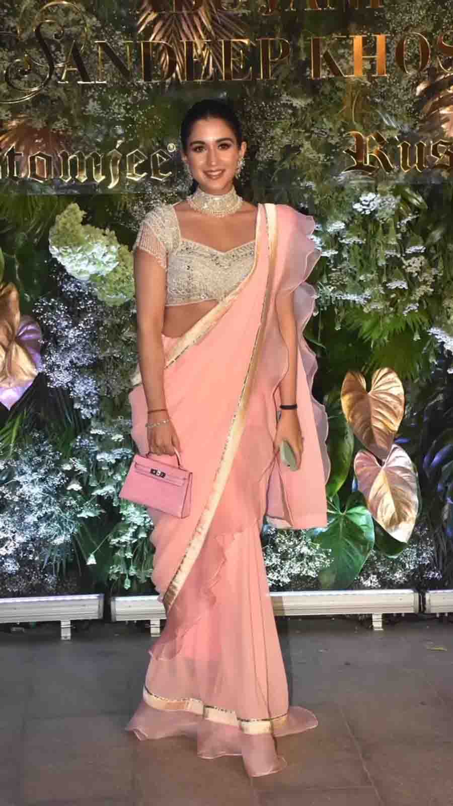 Anant Ambani’s fiance Radhika Merchant showed up in a light pink sari paired with a white sequinned blouse, a stunning choker, and a Birkin bag. 