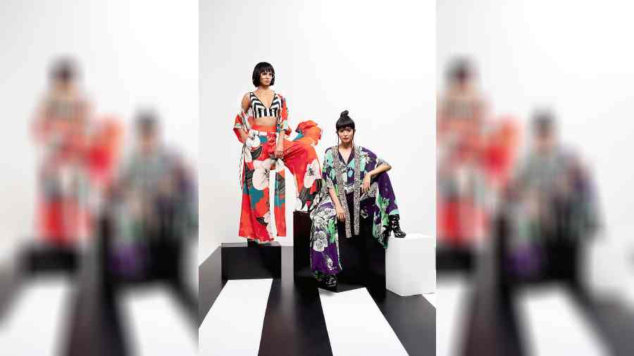 Ankita paired the signature pant set with a gathered kimono jacket in bright orange and a striped bustier. Julaikha complemented the frame in a purple kaftan jumpsuit with black-and-white print detailing on the sleeves and in front.