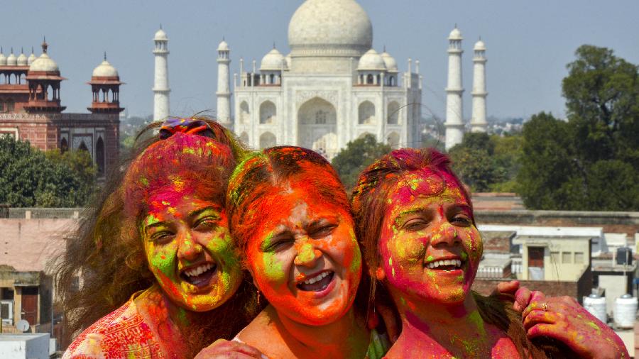 Women play with colours ahead of the festival of Holi, in the backdrop of the Taj Mahal, in Agra. 