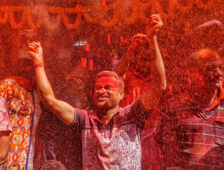 A man in south Kolkata dances in a shower of red ‘gulaal’