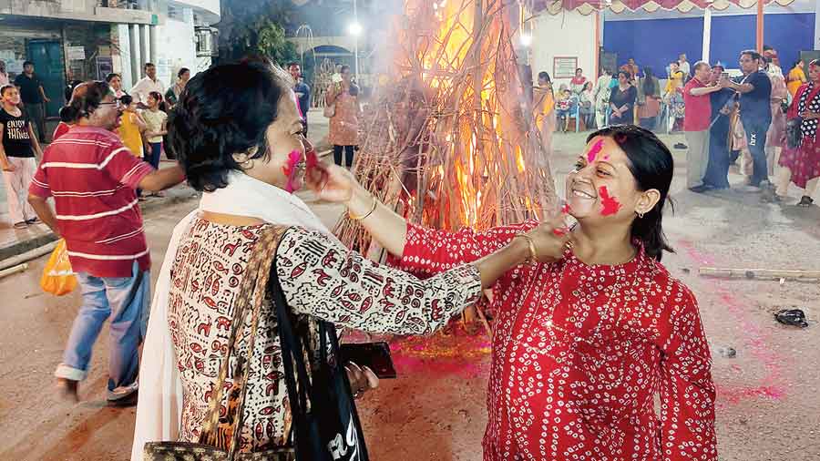 Women smear each other with abir during Holika dahan in AE Block. Pictures by Debasmita Bhattacharjee