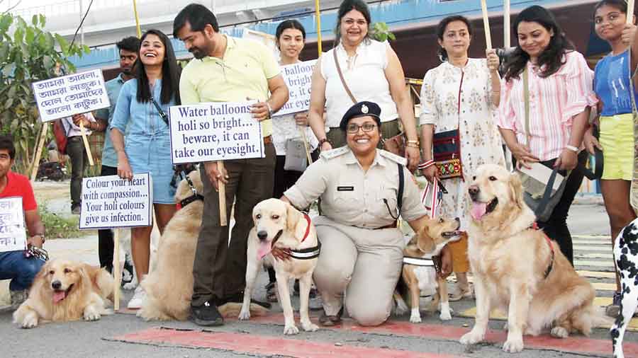 Dog owners with their pets and awareness-raising placards 