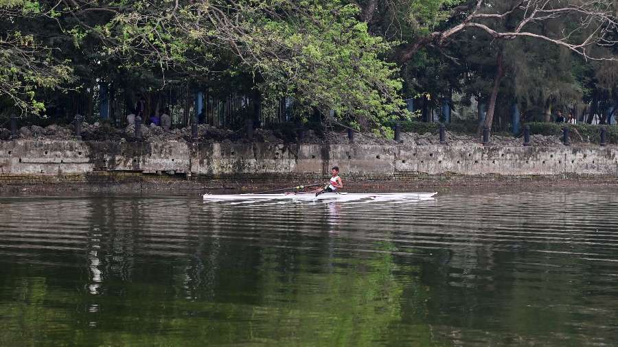 A rower on a boat near the banks of Rabindra Sarobar. Multiple boats have got stuck in the slush beneath the shallow water in the past few weeks