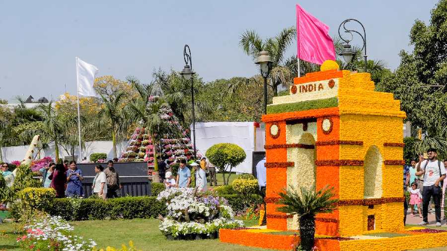 Visitor near a flower-made replica of the India Gate during the inauguration of the G20 Flower Festival at Central Park of the Connaught Place, in New Delhi.