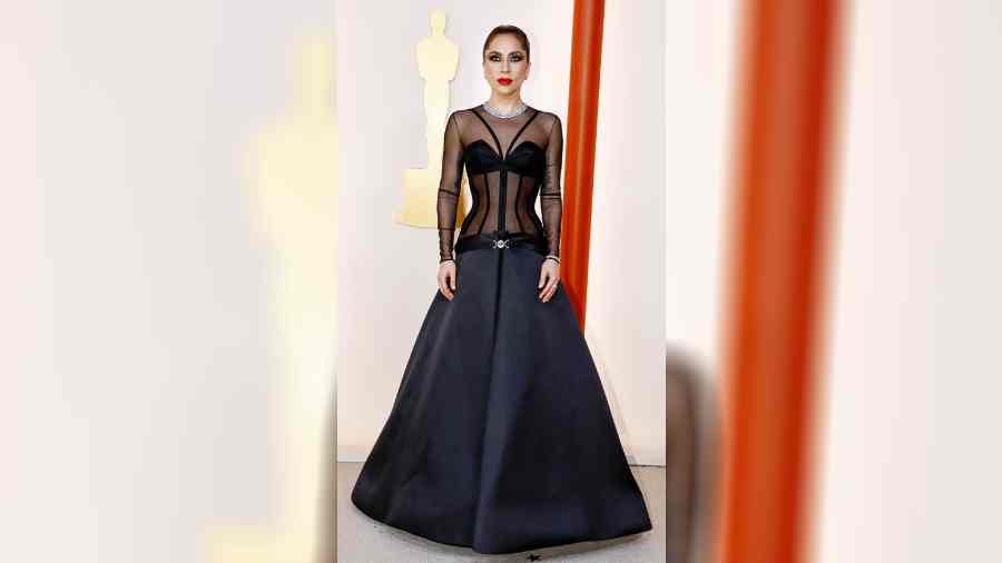 Lady Gaga’s outfit was as fresh as it could get! The singer-actor strutted about in a black Versace outfit that was seen for the first time last week at Donatella Versace’s fall 2023 collection in Los Angeles. The gown had a sheer top while it was its super low-cut back that turned heads, quite literally! Bold red glossy lips, dramatic eyes and diamonds complemented Gaga’s personality.