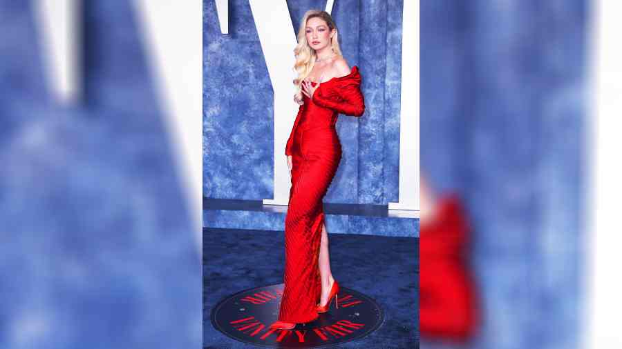 Gigi Hadid looked riveting in an off-the-shoulder skintight red dress with matching red heels. She wore her long blonde curls on one side with winged eyes, silver necklace and rings. 