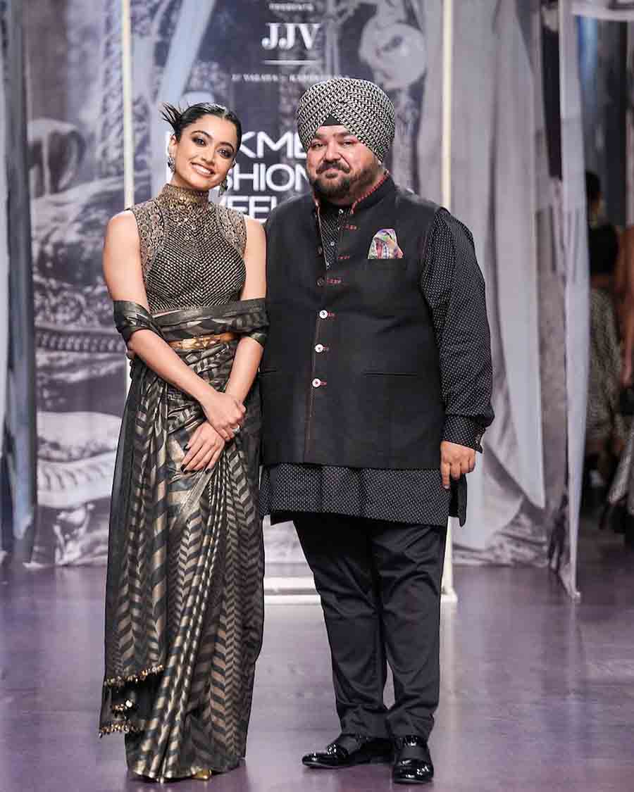 Rashmika Mandanna turned muse for J.J. Valaya in a black and gold sari draped around the waist and paired it with a high neck embellished blouse. 