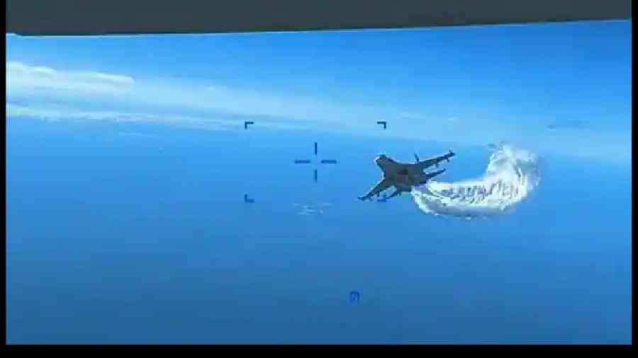 A picture taken from a handout video shows the Russian Su-27 military aircraft dumping fuel while flying towards the US MQ-9 Reaper drone over the Black Sea on Tuesday. 