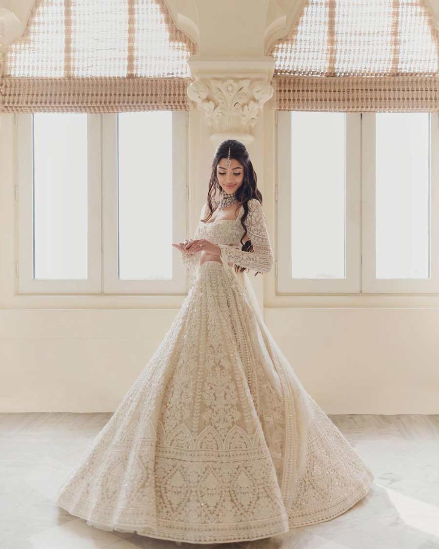 Alanna wore a white embroidered lehenga. The outfit had features of the Christian wedding gown with a veil.