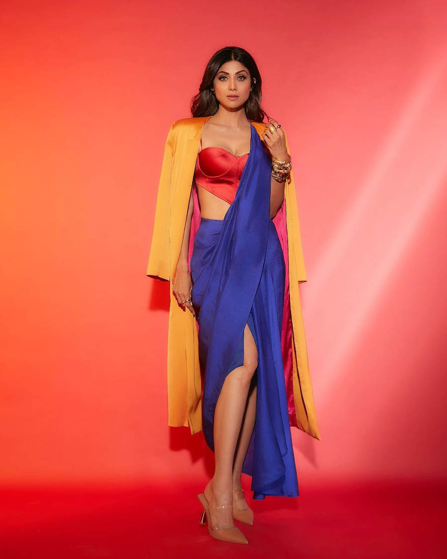 The yoga enthusiast aced the colour-block look in a satin blue sari paired with a red corset blouse and a mustard yellow coat. 