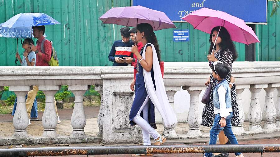 Pedestrians amid a light drizzle on Theatre Road on Saturday afternoon