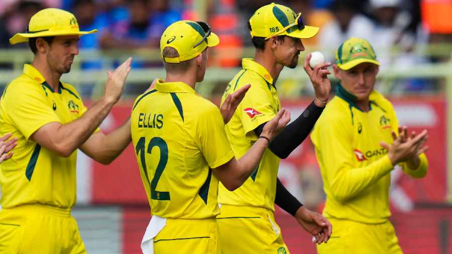 Australia's Mitchell Starc shows the ball after taking five wickets as his teammates applaud during the second ODI cricket match between India and Australia, at Dr. Y.S. Rajasekhara Reddy International Cricket Stadium in Visakhapatnam