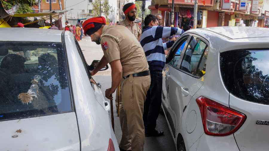 Police personnel check a vehicle amid a crackdown against 'Waris Punjab De' chief Amritpal Singh and his aides, in Amritsar