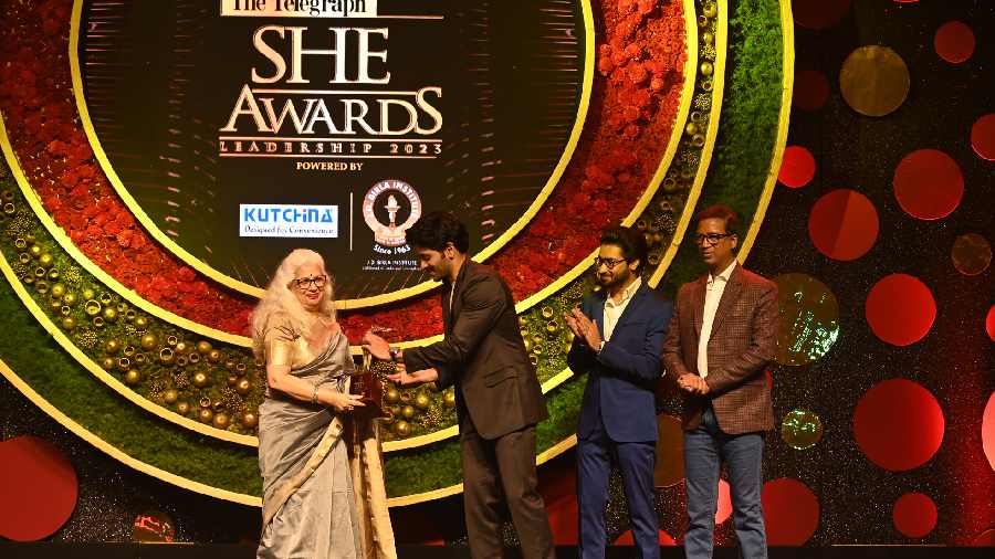 Dolly Basu accepts her award from Arjun Chakrabarty, Gaurav Chakrabarty and Namit Bajoria