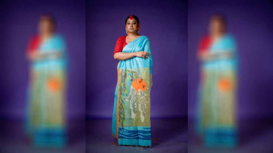 A matka silk jamdani in blue with a scene of sunset captured on the aanchal.