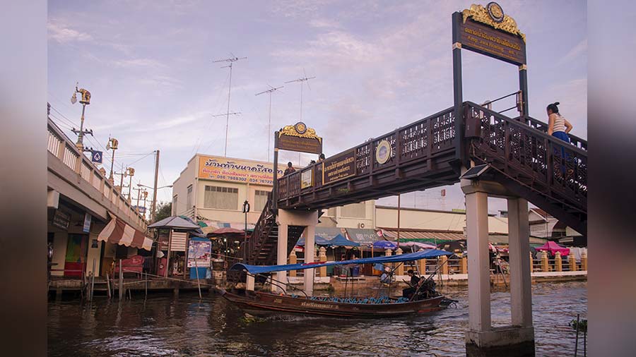 A wooden pedestrian bridge spanning across the Amphawa Canal