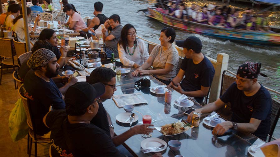 Tourists enjoy a fine dining experience at the Amphawa Floating Market