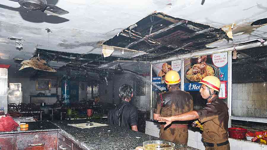 Firefighters inspect the damaged restaurant