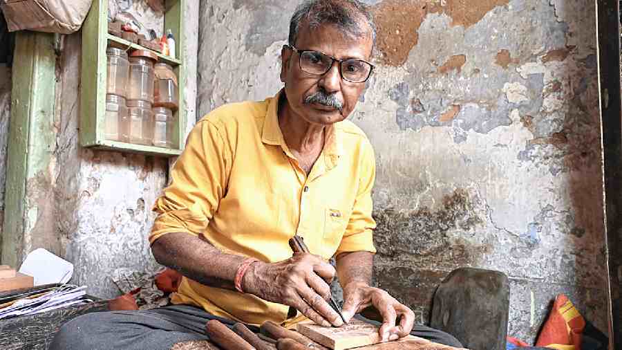 Ashim Das works on a sandesh mould at his shop on Rabindra Sarani.