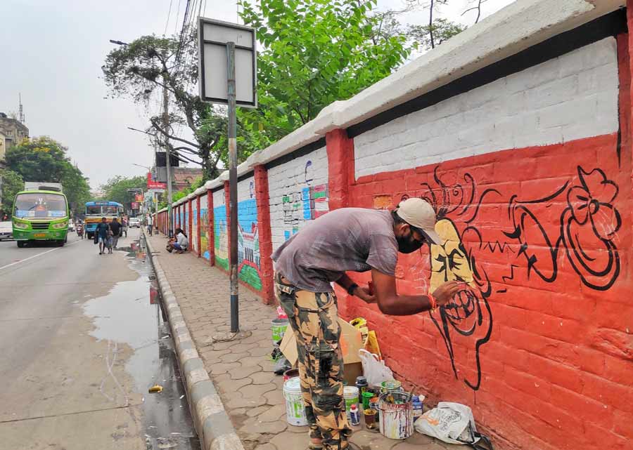 A man draws graffiti on a wall near Burrabazar on Monday 
