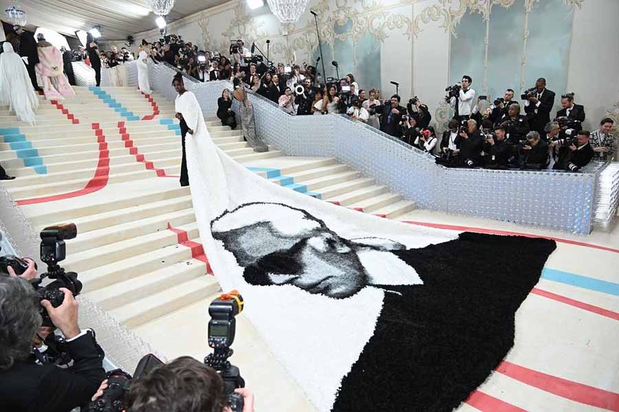 Jeremy Pope turned heads in a custom Karl-inspired cape and flared pants by Balmain for the 2023 Met Gala. 