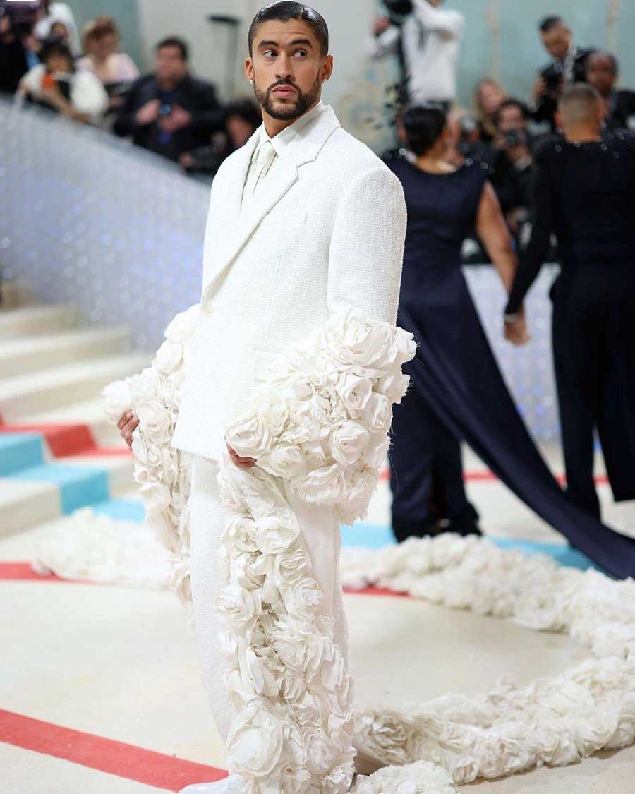 Rapper Bad Bunny showed up in style in a custom white Jacquemus suit with rose adorning the sleeves and an open back. 