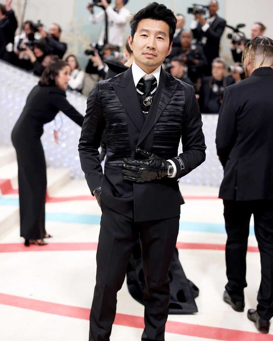 Simu Liu wore custom Versace to the MET Gala, opting for a double-breasted blazer with a high-neck collar and a custom tie pin. 