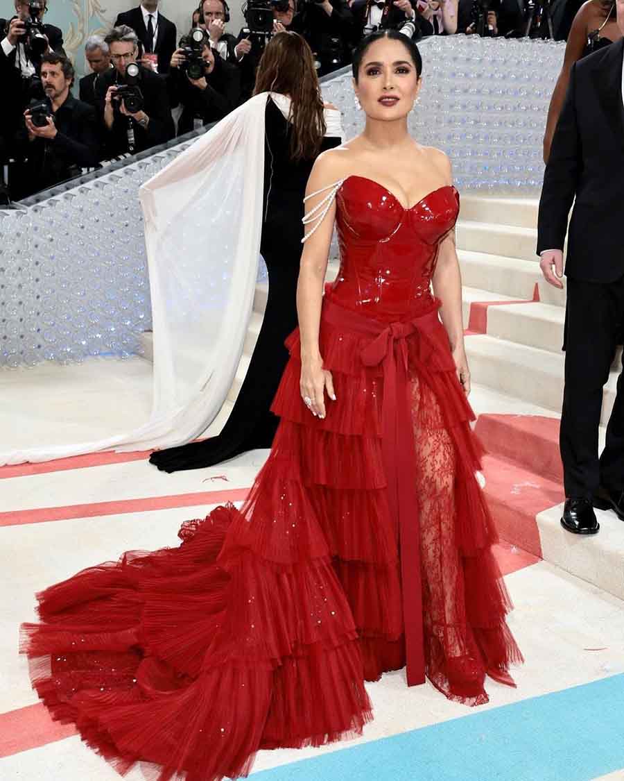Salma Hayek looked stunning in a red Gucci gown with a corset top and pearl-stringed sleeves. 