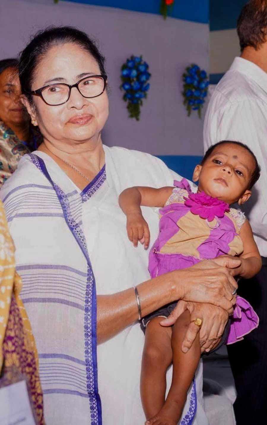 Chief minister Mamata Banerjee poses with a child in Murshidabad during a programme on Friday 