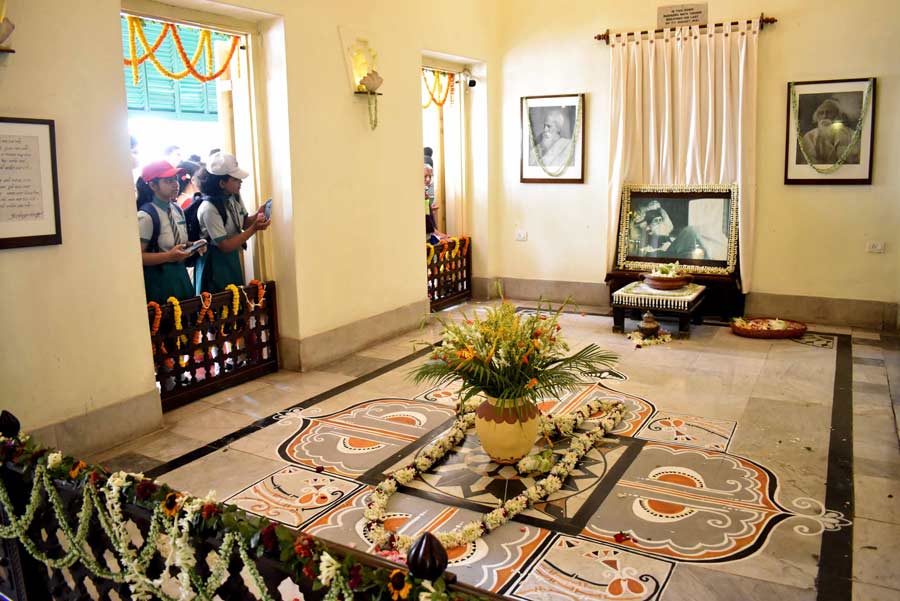 Visitors click photographs of the floral decorations in one of the rooms used by Rabindranath Tagore at Jorasanko Thakurbari on his 162nd birth anniversary on Tuesday