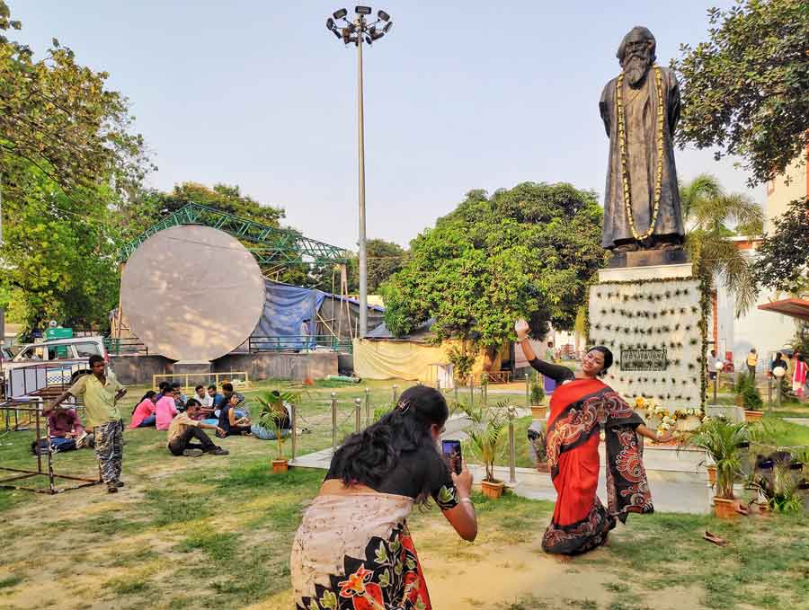 A woman strikes a dancing pose in front of the bard’s statue at Rabindra Sadan on Tuesday evening