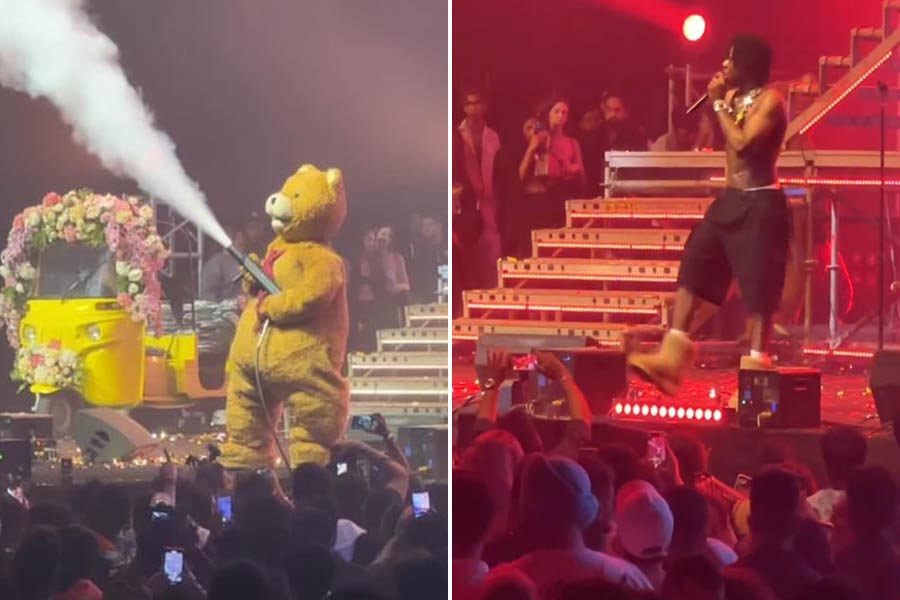 Rema wearing a teddy bear costume, with a smoke blower