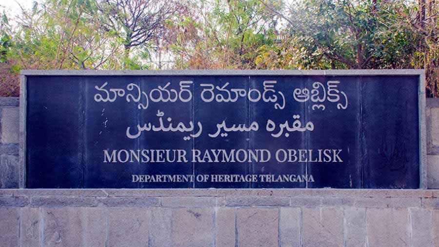 A trilingual plaque welcomes visitors to the Raymond's Tomb complex