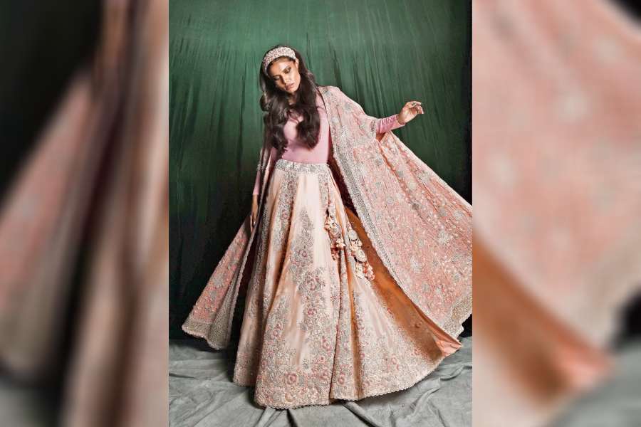Straight out of a fairy tale, Ankita gives a charming princessy vibe in the powder pink silk organza lehnga with silver embroidery all over. It is paired with a georgette cape, detailed with thread embroidery, making it ideal as an engagement wear.