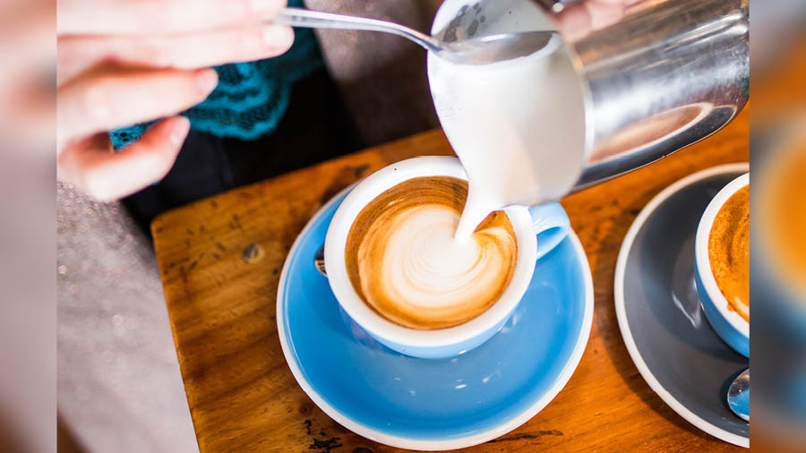 A barista pours a Flat White, which almost finds that perfect balance between coffee and milk 